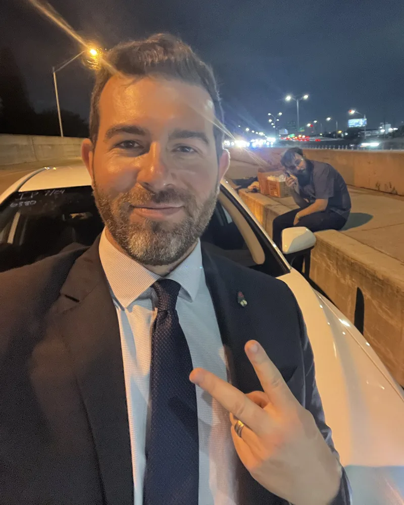 Oliver Larkin takes a late-night selfie near a highway barrier following an event