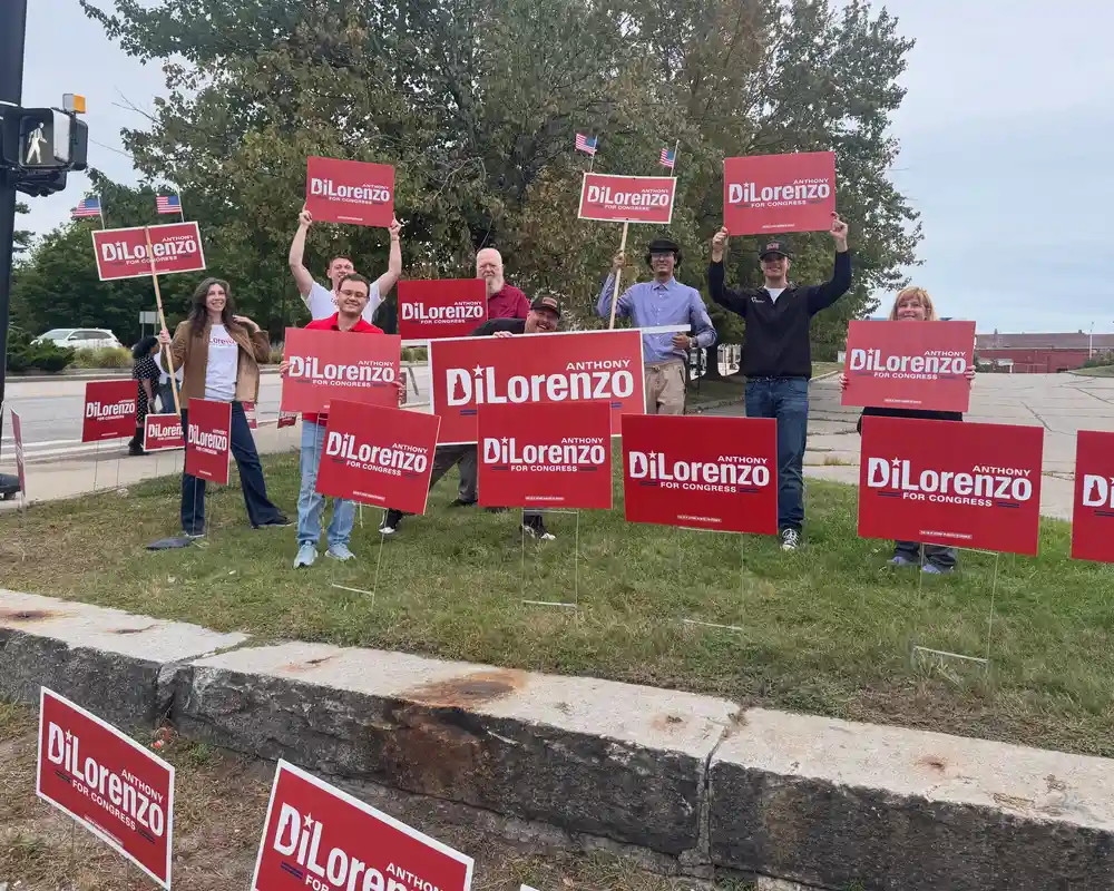 Supporters display campaign signs for Congressional candidate Anthony DiLorenzo ahead of his debate